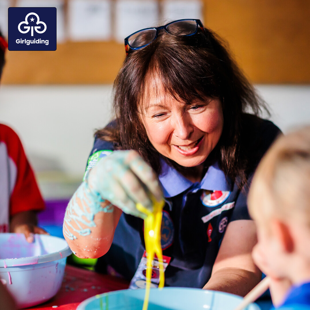 Volunteer playing with slime as part of an activity